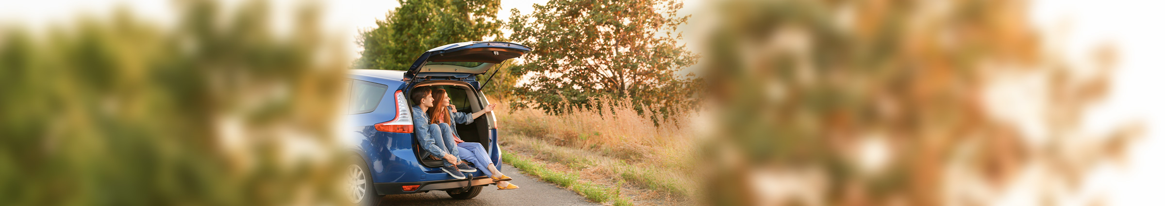 Couple sitting in trunk of a car