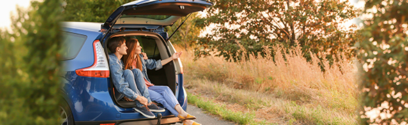 Couple sitting in trunk of a car