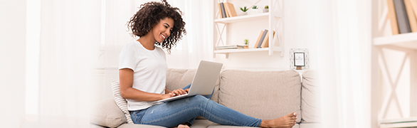 Woman sitting on couch with laptop