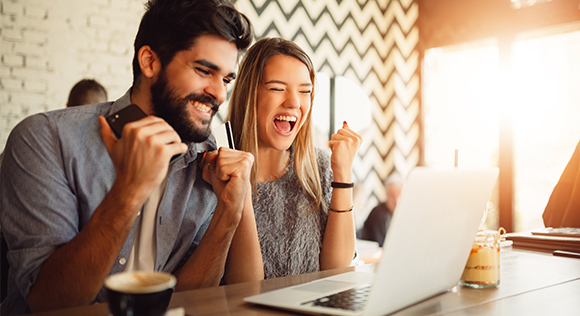 Couple smiling in front of a computer