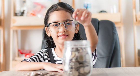 Girl putting money in a jar